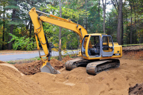 a yellow construction vehicle with a bucket on dirt